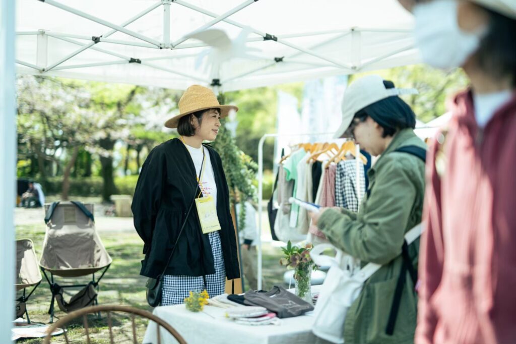 衣服のブースで言葉を交わす作家と来場者